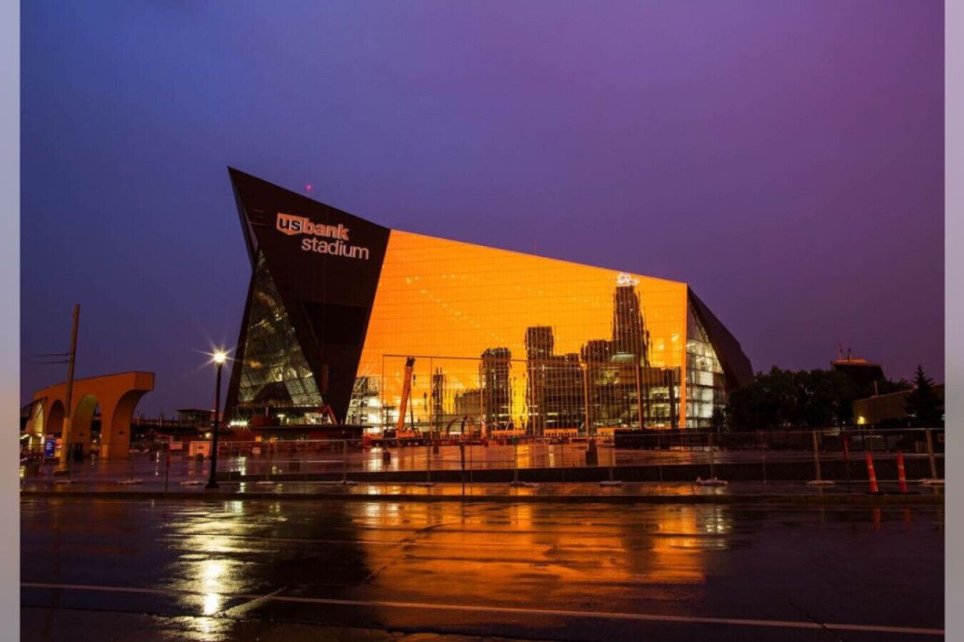 A modern stadium with a distinctive angular design, featuring a large reflective surface and the text "USbank stadium" on its facade.