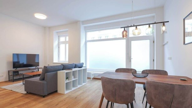 A modern living room with a sofa, TV, dining table, and chairs. - Berlinkiez (Berlin)