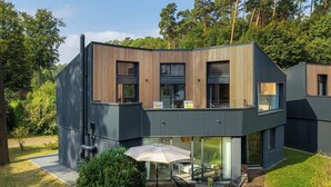 A modern two-story house with a flat roof, large windows, and a balcony. - Haus 1 - ELF AM SEE (Templin)