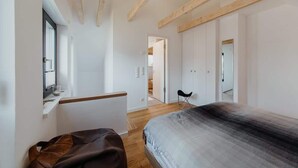 A bedroom with a bed, a window, a chair, and a wardrobe. - Holiday Home SandDorn 1 (Pruchten)