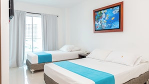 Habitación de hotel con dos camas, un cuadro de peces en la pared y una ventana con cortinas.