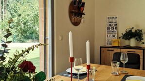 A dining table with candles, glasses, and a potted plant.