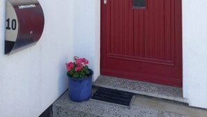 A red door with a mail slot and a mailbox with the number 10.