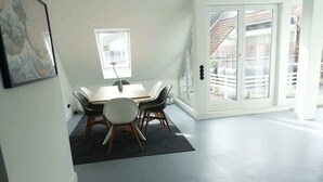 A dining area with a table and chairs, a window, and a view of the outside. - DUS-Loft (Düsseldorf)