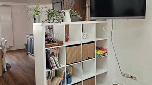A modern living room with a white entertainment unit, a flat-screen TV, and a wooden floor.