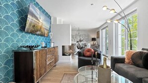 Ein modernes Wohnzimmer mit einem Glastisch, einer Couch und einem Schrank.