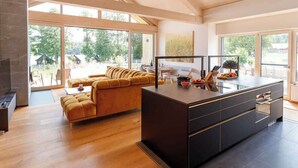 A modern kitchen with a central island, large windows, and a cozy seating area. - Refugio del Lago Zechlin (Rheinsberg)