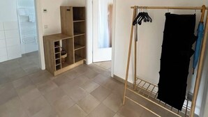 A spacious room with a wooden wardrobe, a clothes rack, and a built-in shelf unit. - Buschwiesen Ausguck (Teltow)