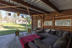 A covered outdoor seating area with a sofa, chairs, and a table. - Ferienhaus Neuland 5 - Entspannung in Seenähe (Lychen)