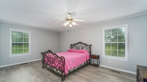 A bedroom with a bed, a ceiling fan, and two windows with blinds. - Peaceful almost 4 acres  pond,sunroom, close to shopping restaurant's Douglas,GA (Douglas)