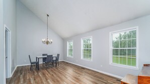 A spacious room with a dining table and chairs, large windows, and a chandelier. - Peaceful almost 4 acres  pond,sunroom, close to shopping restaurant's Douglas,GA (Douglas)