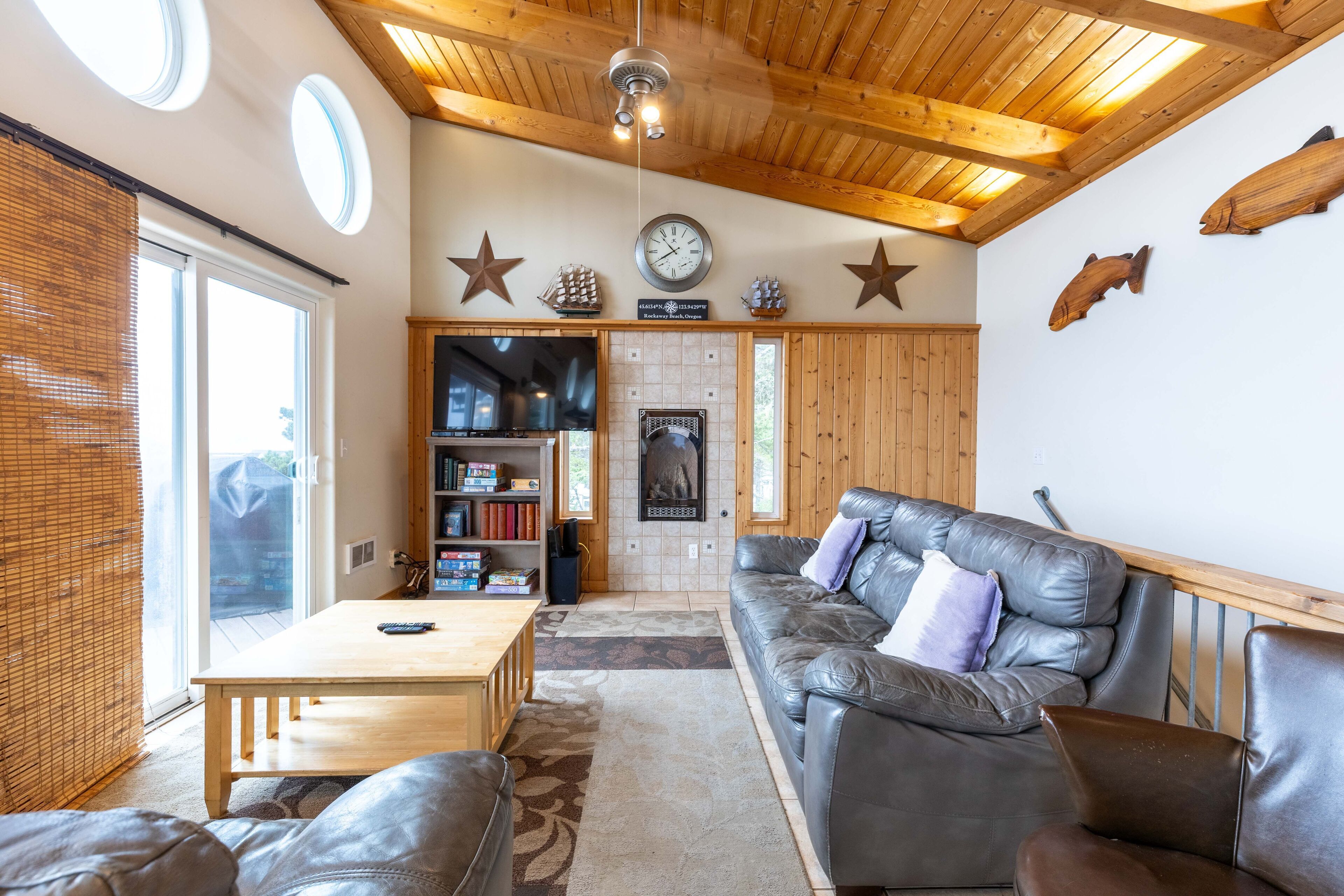 A cozy living room with a leather sofa, a wooden coffee table, and a bookshelf.