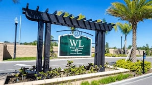A sign for West Lucida Village Resort with a pergola structure in front. - Family Getaway 3BR 2BA Lucaya Resort (Kissimmee)