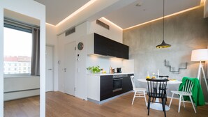 A modern kitchen with a dining area, featuring a built-in oven, a sink, and a dining table with chairs.