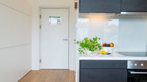 A modern kitchen with dark cabinets, a white countertop, and a stainless steel oven.