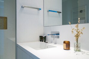 A bathroom with a white sink, a mirror, a towel rack, and a candle. - Vienna Residence, Philips Haus - Euro Plaza #6554 (Vienna)