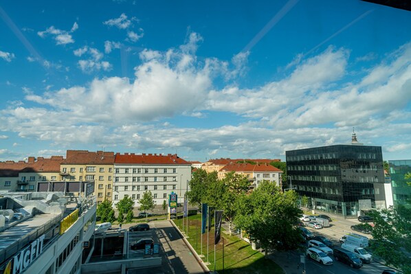 A cityscape with a modern building, a parking lot, and a clear sky.