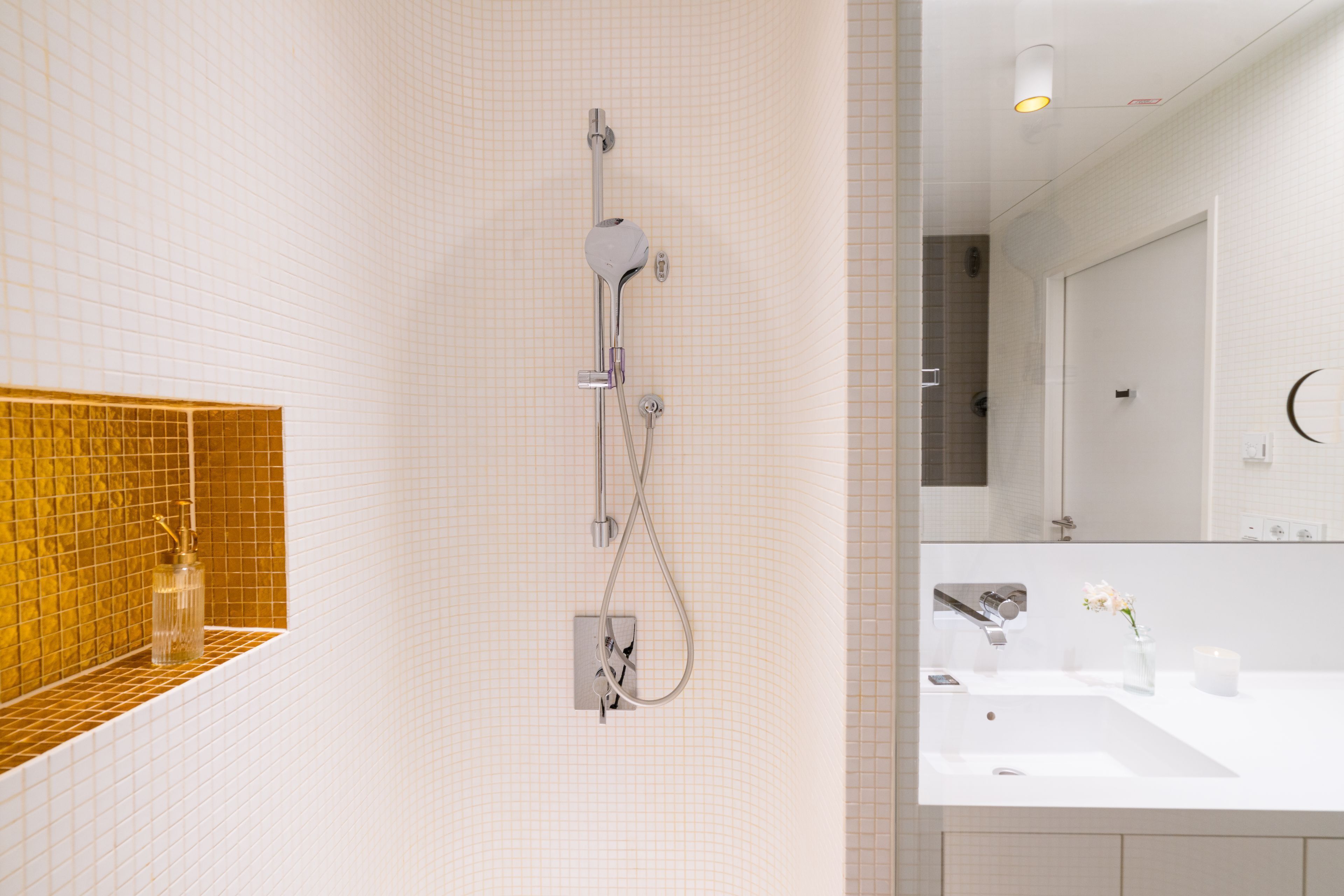 Une salle de bain moderne avec une douche, un lavabo et un miroir.