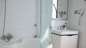 A bathroom with a bathtub, a sink, and a mirror. - Hotel vista velero (Vina del Mar)