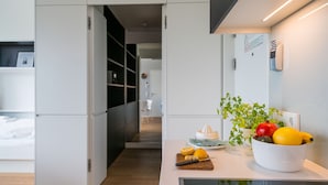 Een moderne keuken met een fruitschaal, een snijplank en een sapcentrifuge.