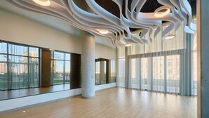 A spacious interior with large windows, a high ceiling with unique lighting, and a modern design. - Sentral Sol Modern (Phoenix)