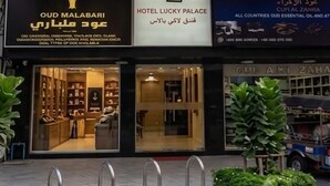A hotel named Lucky Palace with a distinctive striped facade and a sign indicating it is Grand 2. - hotel lucky palace  (Bangkok)