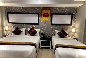 A hotel room with two beds, a nightstand between them, and a floral wallpaper. - hotel lucky palace  (Bangkok)