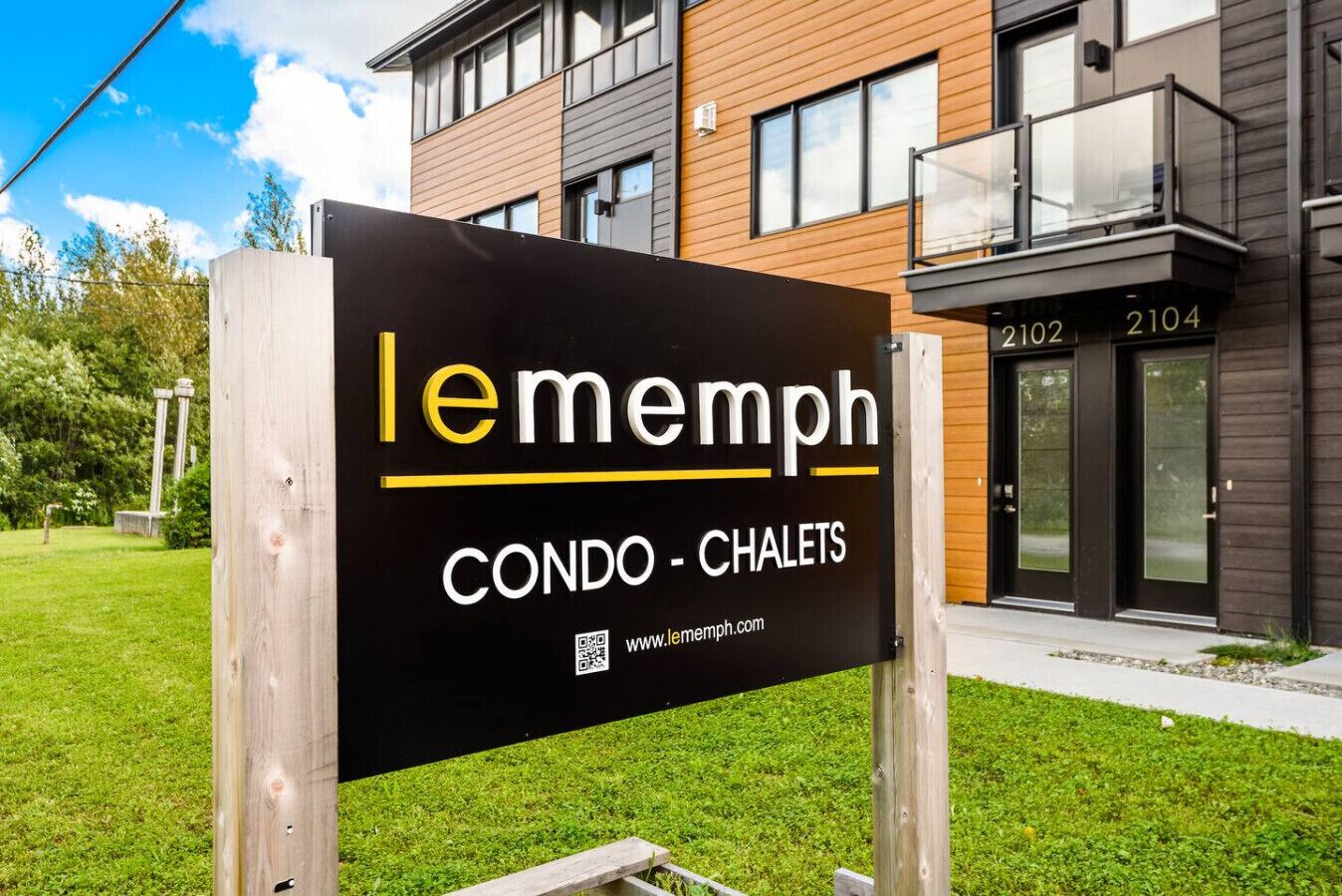A sign for Lememph Condo - Chalets with a modern building in the background.