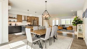 Una cucina moderna con isola centrale, mobili in legno e illuminazione a sospensione.