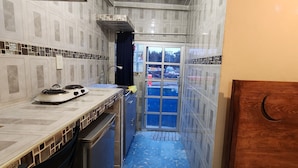 Una cocina estrecha con estufa, lavamanos y armarios.