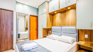 A modern bedroom with a bed, wooden wardrobe, and a mirror. - Apt w/ Balcony Sudoeste - Por0017 (Sudoeste e Octogonal)