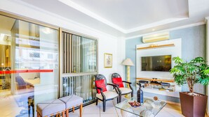 A modern living room with a glass partition, a sofa set, a TV, and a potted plant. - Apt w/ Balcony Sudoeste - Por0017 (Sudoeste e Octogonal)