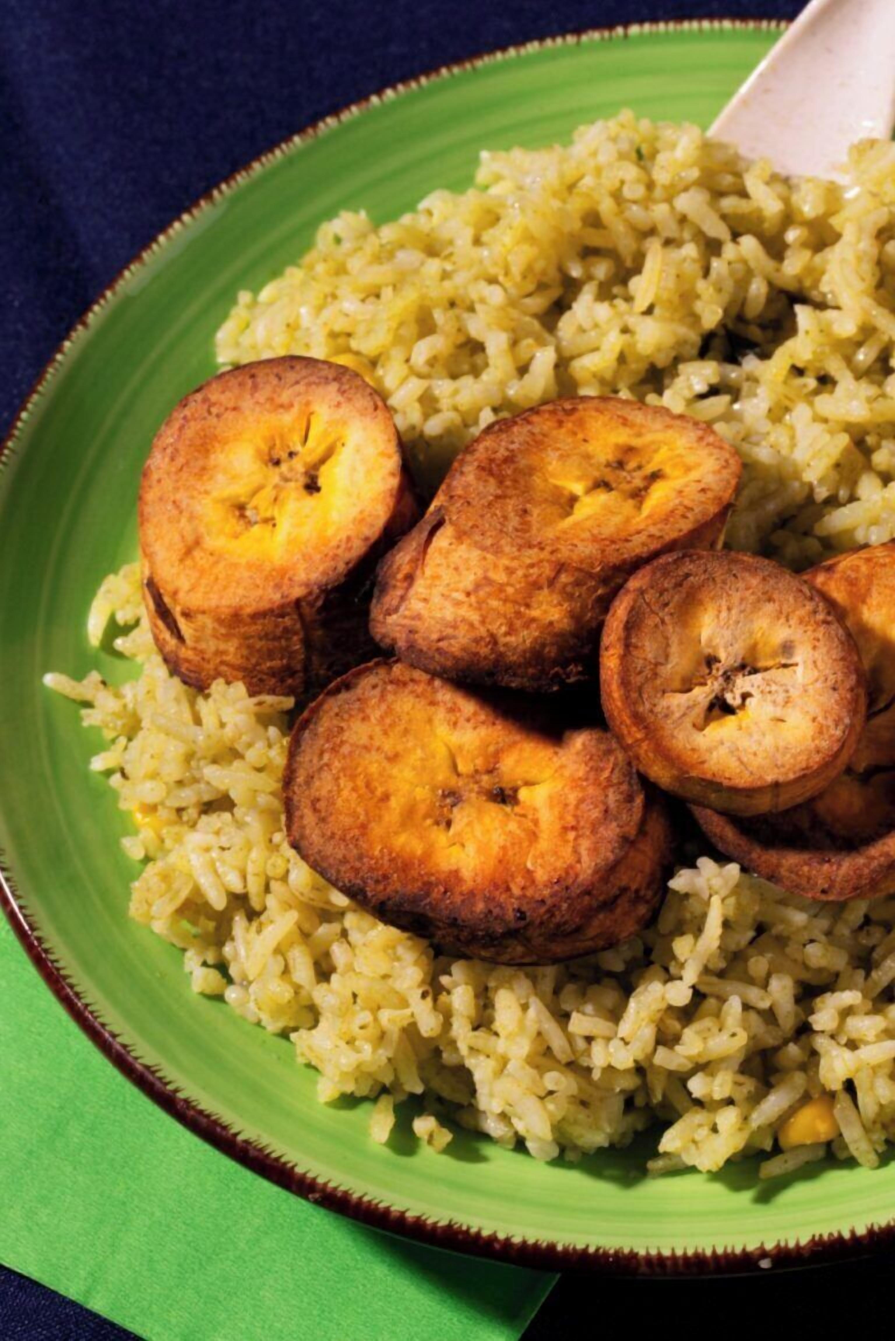 A plate of yellow rice with fried plantains.