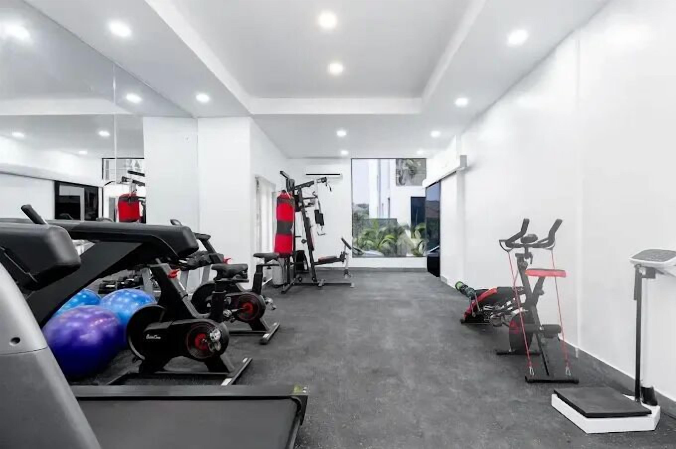 A modern gym with various exercise equipment, including treadmills, stationary bikes, and weight machines.