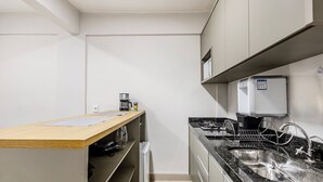 A compact kitchen with a coffee machine, a microwave, and a built-in dishwasher. - Charming Studio Taguatinga Norte - Rjt0104 (Taguatinga)