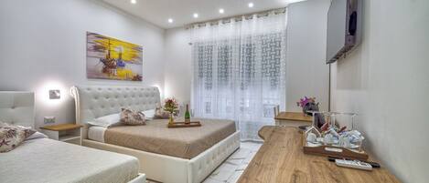 A modern bedroom with a bed, a wooden desk, and a TV.