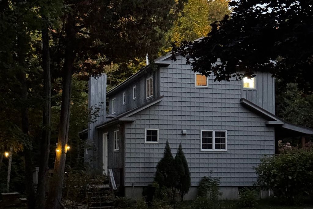 Une maison à deux étages, dotée d’un toit à pignon et d’un porche à l’avant.