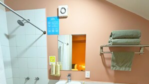 Ein Badezimmer mit Dusche, Waschbecken, Toilette und Handtuchhalter.