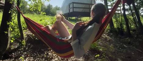 A hammock in a wooded area with a clear view of a large dome structure in the background.