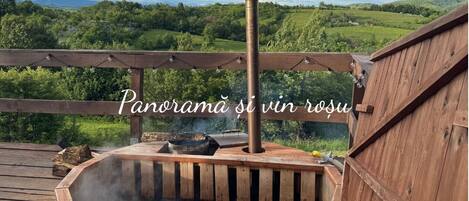 Un jacuzzi con terraza de madera y vistas al campo.