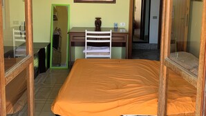 A room with a bed, a desk, a chair, a mirror, and a hanging light fixture. - Villa Panorama (Bivio Acquavella)
