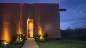 A modern building with a central entrance, flanked by large, illuminated panels. - Casa Salpico - Docas do Rosa - SC (Imbituba)