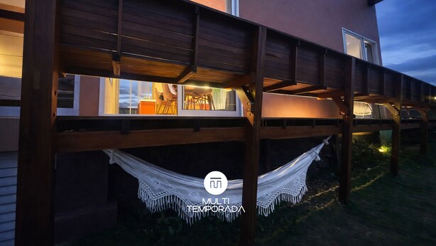A modern building with a wooden deck and a hammock. - Casa Salpico - Docas do Rosa - SC (Imbituba)