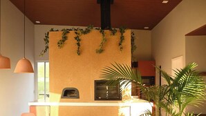 A kitchen with a built-in oven, pendant lights, and a wall-mounted plant. - Casa Salpico - Docas do Rosa - SC (Imbituba)