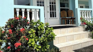 A house with a porch, white doors, and a small set of stairs leading to the entrance. - A3  Comfy 1BR Near Pool, Caribbean Sea Steps Away! (San Pedro)
