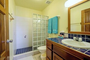 A bathroom with a shower, toilet, and sink.