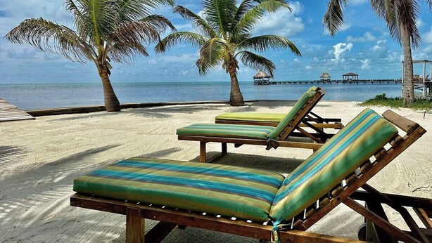 A beach with lounge chairs and palm trees. - A6 Modern 3BR with Stunning Views! (San Pedro)