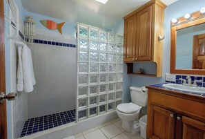 A bathroom with a shower, toilet, and sink.