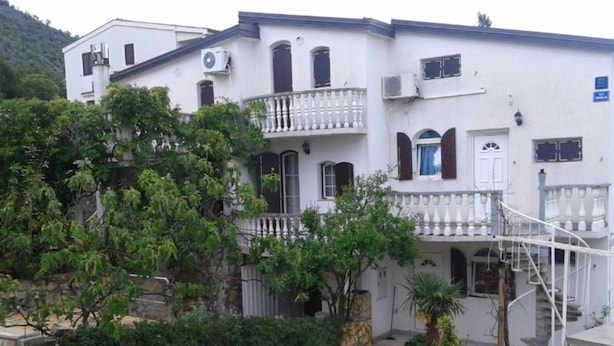 A two-story building with a stone staircase leading to a balcony. - Apartments Marija in National Park Area - Studio Apartment (Starigrad-Paklenica)