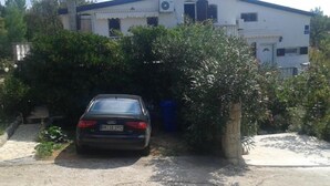 A two-story house with a car parked in the driveway. - Apartments Marija in National Park Area - Studio Apartment (Starigrad-Paklenica)